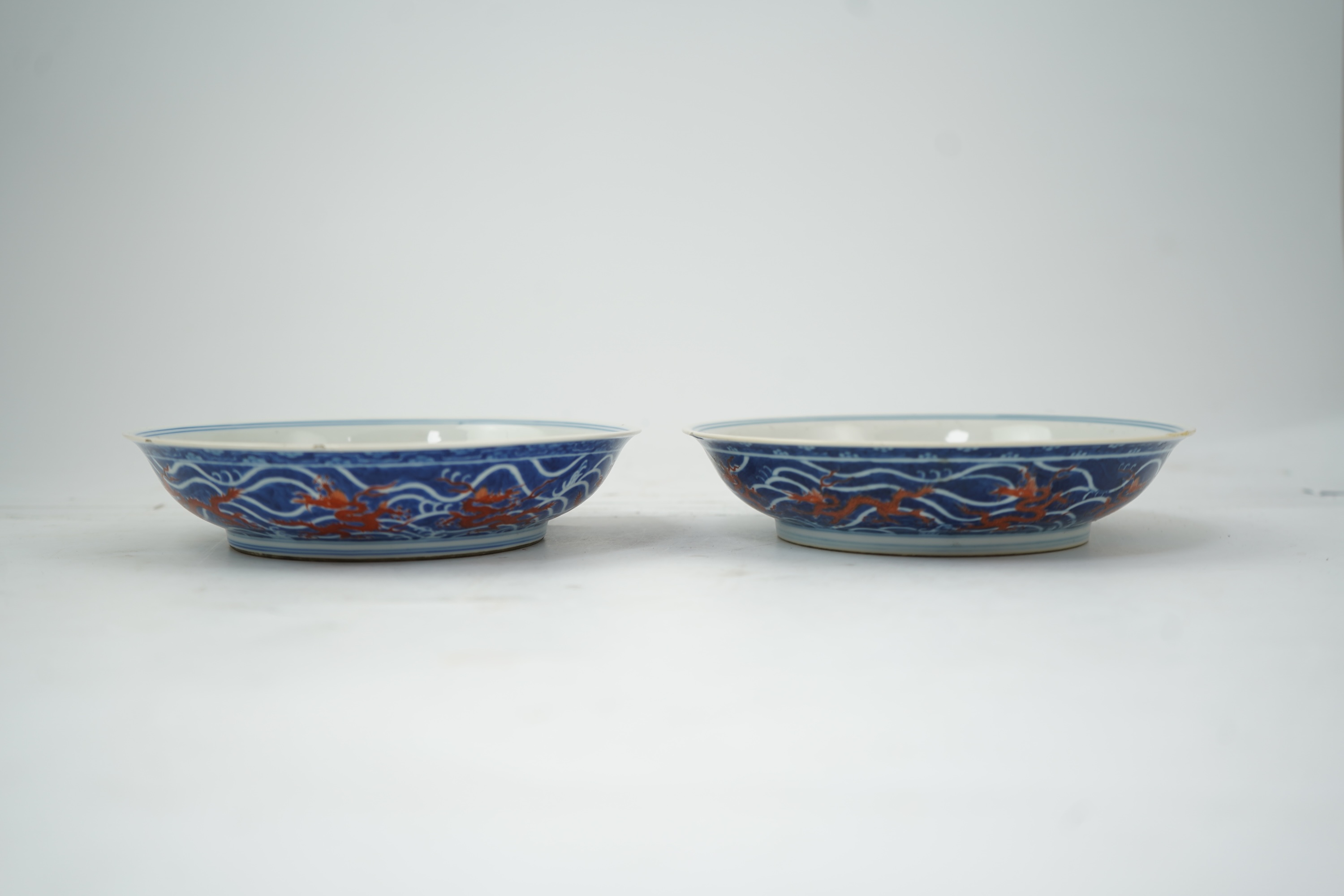 A pair of Chinese iron red and underglaze blue ‘dragon’ dishes, Qianlong seal mark and of the period (1736-95)